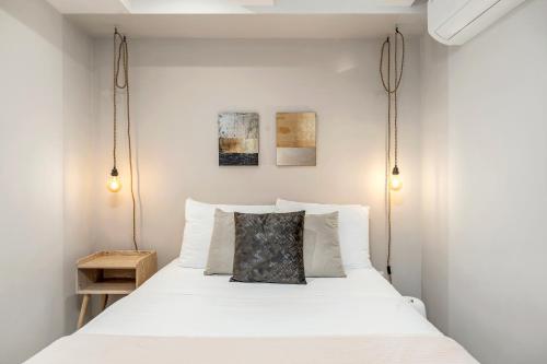 a bedroom with a white bed with two hanging lights at Mohk Boutique by HOUSY HOST in Medellín