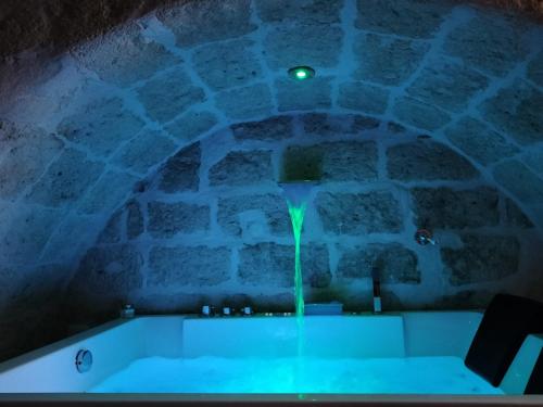 eine Badewanne mit grünem Licht in einem Steinzimmer in der Unterkunft Casa Perricci - short lets - Monopoli (BA) in Monopoli