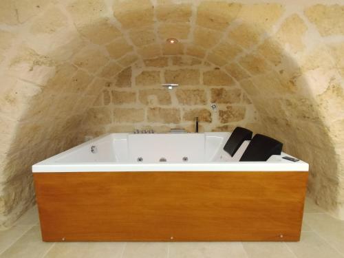 Cette chambre dispose d'une baignoire et d'un mur en pierre. dans l'établissement Casa Perricci - short lets - Monopoli (BA), à Monopoli