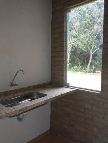 cocina con fregadero y ventana en Casa do Bosque, en Aiuruoca