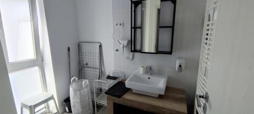 uma casa de banho branca com um lavatório e um espelho em FreshGarden Family Resort em Siófok