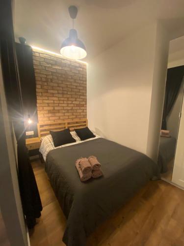 Chillout Loft Apartment AL20 في وارسو: غرفة نوم بسرير كبير وجدار من الطوب