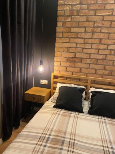 um quarto com uma cama e uma parede de tijolos em Chillout Loft Apartment AL20 em Varsóvia