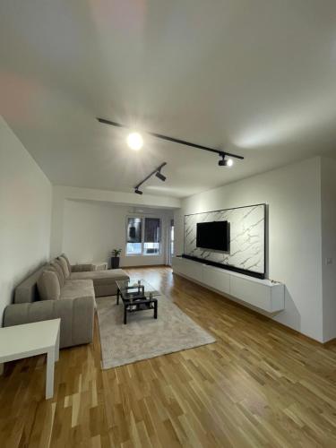 a living room with a couch and a tv on a wall at Diamond Apartment in Strumica