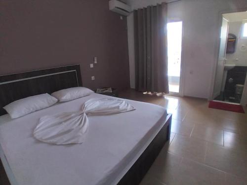 a bed with white sheets and pillows in a bedroom at Vila DINI Ksamil in Ksamil