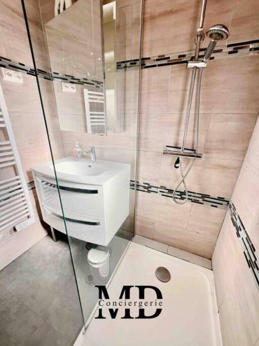 une salle de bain avec un lavabo blanc et une douche dans l'établissement Appartement T3 • Plage à 300m • Les Oursinières, au Pradet