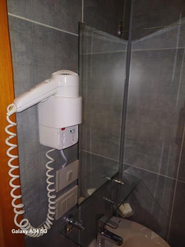 a blow dryer is hanging in a bathroom mirror at Palm Inn Hotel Hurghda in Hurghada