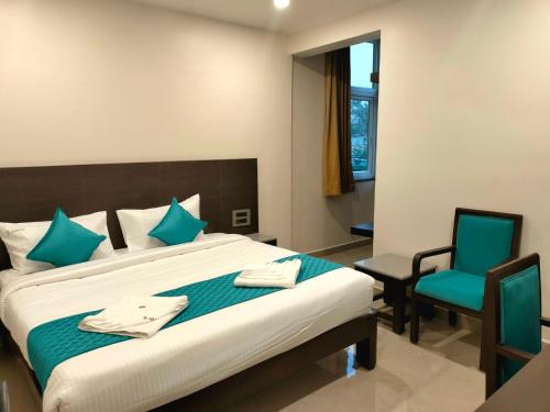 a bedroom with a large bed and two chairs at Hotel JANAS in Tirupati