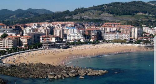 a beach with a bunch of people in the water at JMCA in Castro-Urdiales