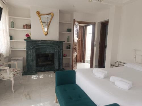 a bedroom with a white bed and a fireplace at Suite Comares in Granada