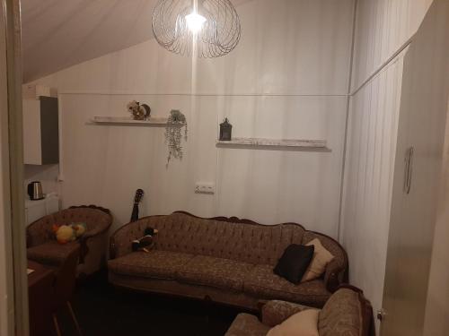 a living room with a couch and a lamp at Guesthouse Holmur in Hólmur