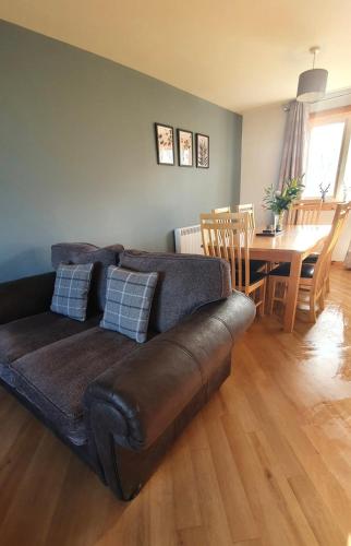 sala de estar con sofá marrón y mesa en No.2 Meallard, en Balivanich