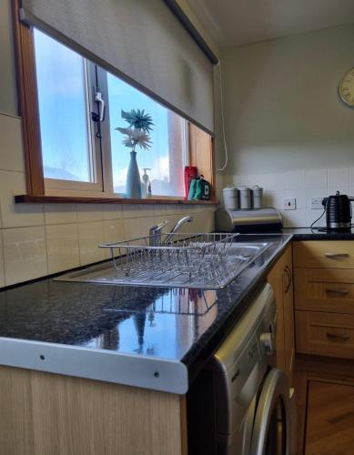 a kitchen with a counter with wine glasses on it at No.2 Meallard in Balivanich