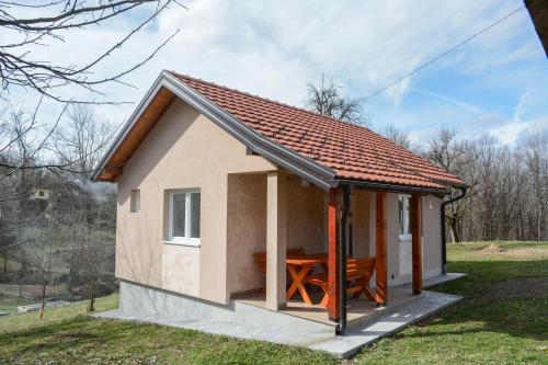 a small house with a table in the yard at Vikendica Batin Konak in Bajina Bašta