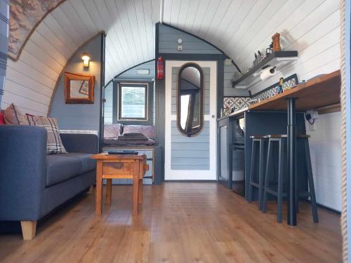 a living room with a couch and a table at Etive Pod, West Highland Way Holidays in Kinlochleven