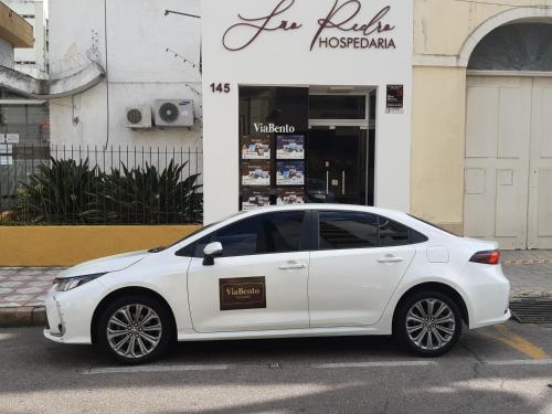 een witte auto geparkeerd voor een winkel bij São Pedro in Pelotas