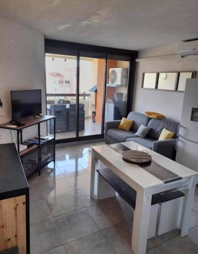 un salon avec un canapé et une table dans l'établissement Chez Fifi au Barcarès, au Barcarès