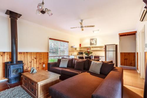 a living room with a couch and a stove at The Cottages at Hepburn Springs in Hepburn Springs
