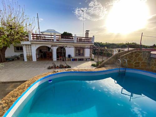 una casa con piscina frente a una casa en Villa Caliqueña, casa de campo, en Torrent