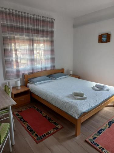 1 dormitorio con cama y ventana en lastva 1&2, en Sveti Filip i Jakov