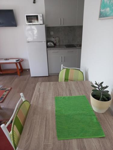 a kitchen with a table with a green mat on it at lastva 1&2 in Sveti Filip i Jakov