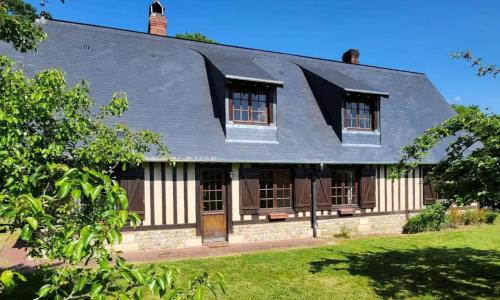 una vecchia casa con tetto di gamberetti di Maison Évasion Normande a Sainte-Opportune-la-Mare