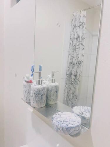 Baño con estante con toallas y espejo en Stylish apartment in Maboneng, en Johannesburgo
