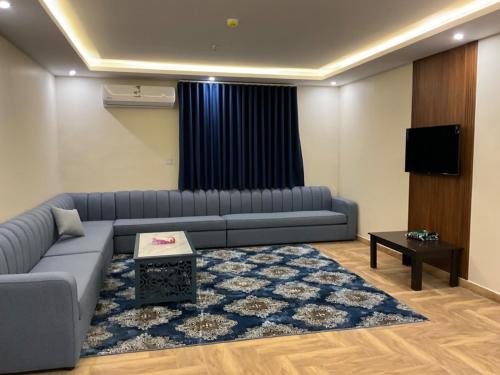 a living room with a couch and a television at Al Baida Suites Al Salam Branch in Al Madinah