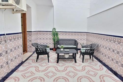 a patio with two chairs and a table on a rug at Casa la perla de sefarad in Lucena