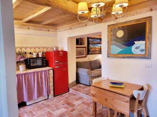 uma cozinha com um frigorífico vermelho e uma mesa em La casa degli artisti em Marliana