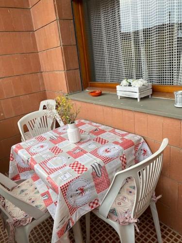 a table and chairs with a quilt on a porch at Casa Lucia a due passi dal mare Wi-Fi free parking in Principina a Mare