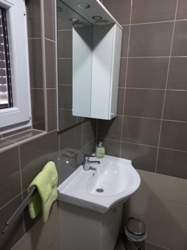 uma casa de banho com um lavatório branco e um espelho. em lastva 1&2 em Sveti Filip i Jakov