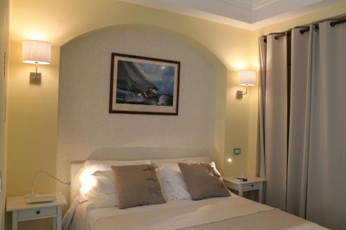 薩雷諾的住宿－SALERNO HOME STATION，一间卧室配有一张带两盏灯的床,墙上挂着一张照片
