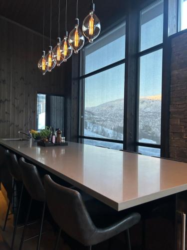 cocina grande con mesa grande y sillas en Pow Panorama - High standard Mountain home en Sogndal