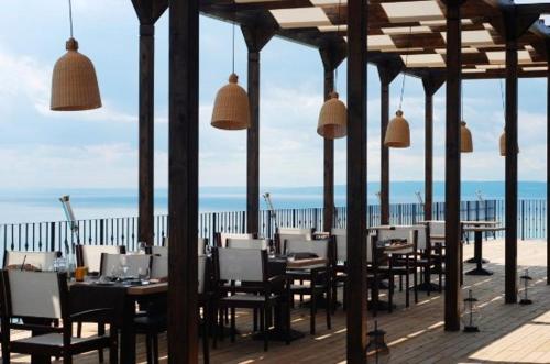 un restaurante con mesas y sillas en la playa en Lux By Kaliakria, en Topola