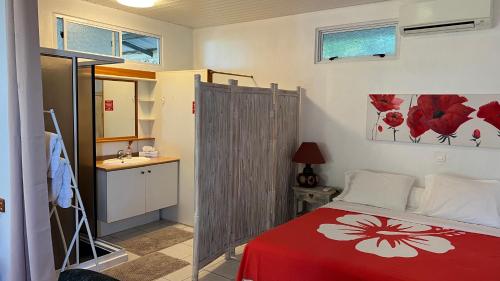 a bedroom with a red and white bed and a sink at DAMYR PLACE in Faaa