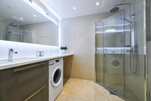 a bathroom with a shower and a washing machine at New waterfront apartment - Oslo city centre in Oslo