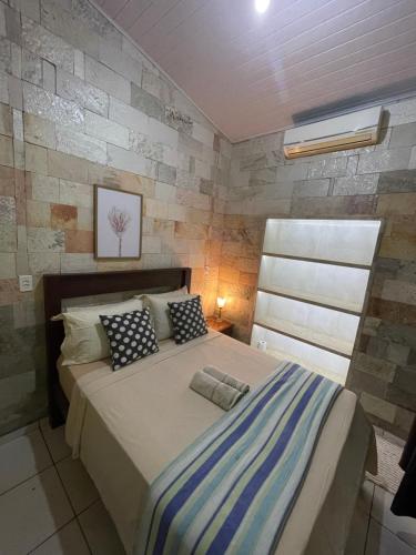 a bedroom with a large bed with two pillows at Casa de Pedra in Pirenópolis