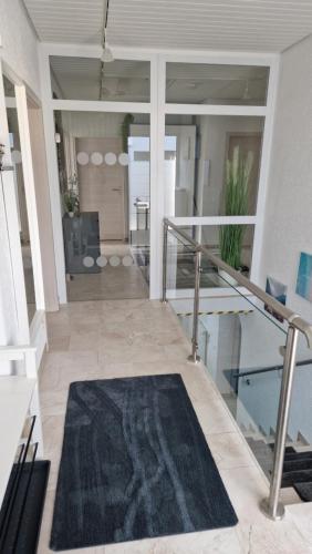 a hallway with a black rug on the floor at Ferienhaus Guldner mit Terrasse, Garten und Sauna in Überherrn