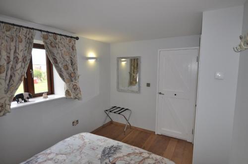 1 dormitorio con cama y ventana en The Wallow, en Penzance