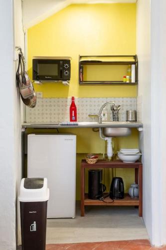 une petite cuisine avec un évier et un micro-ondes dans l'établissement Centre Palais des Papes B3 Clim - 123avignon, à Avignon