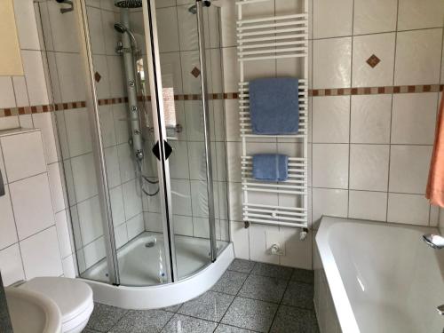 łazienka z prysznicem, wanną i toaletą w obiekcie Ferienhaus Erdmann-Huus w mieście Esgrus