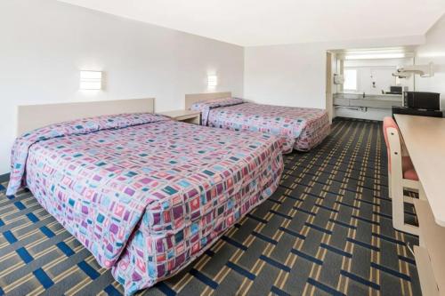 a hotel room with two beds and a television at Hilliard Motor Lodge in Hilliard