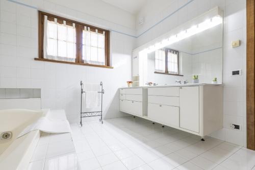 Baño blanco con bañera y lavamanos en Villa intera San Marco - Luxury Wine Resort, en Rosignano Monferrato