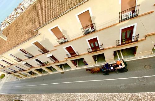 two people sitting on a table in front of a building at Apartamentos Abeto in Ronda