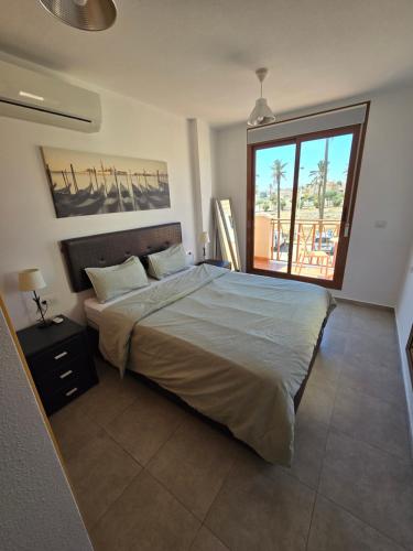 a bedroom with a bed and a large window at Duplex 6 Mar de Plata in Puerto de Mazarrón