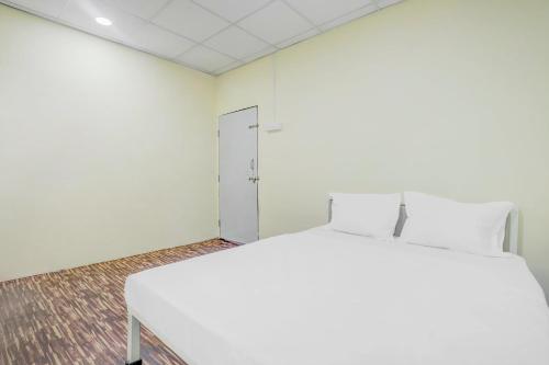 ein weißes Bett in einem Zimmer mit einer Tür in der Unterkunft OYO Flagship 81020 Hotel Radhe Krishna in Nagpur