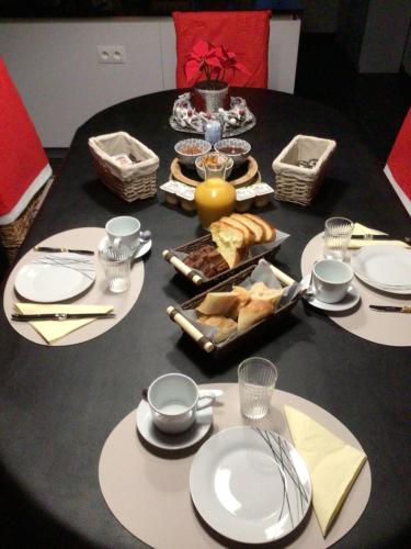 een zwarte tafel met borden en voedsel erop bij Domaine de Grisere in Tilh