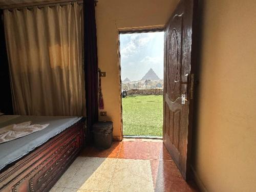 a bedroom with an open door with a view of a pyramid at moon light pyramids inn in Cairo