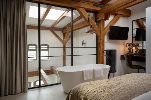 a bedroom with a bath tub and a bed at Loft 16 in Iława